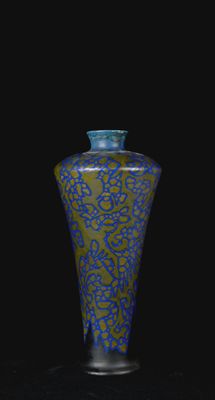 vase bleu et vert sur une surface noire, avec un fond noir