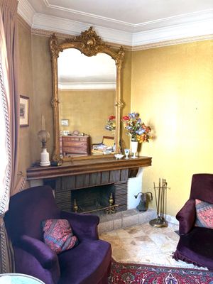 a living room with two purple chairs and a mirror