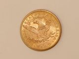 a close up of a gold coin on a white surface