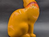 a yellow cat figurine sitting on a gray surface
