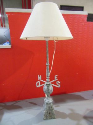 a lamp that is on a table with a red wall in the background