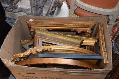 une boîte remplie de cadres et une chaise à l'arrière-plan