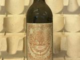 une bouteille de vin posée devant un mur de tasses