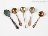 six spoons are lined up in a row on a white surface