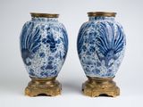 une paire de vases bleus et blancs posés sur un socle doré