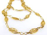 gros plan d'un collier en or sur fond blanc