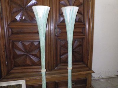 deux grands vases posés sur une table devant une armoire en bois