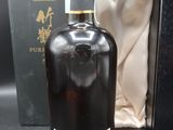 une image représentant une bouteille de whisky dans une boîte noire