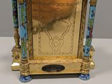 a gold and blue clock sitting on top of a table