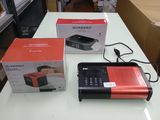 une radio rouge et noire posée sur une table à côté d'une boîte