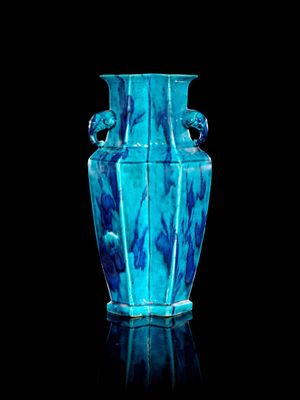 un vase bleu posé sur une surface noire
