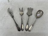 four silver spoons and a fork on a white surface