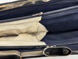a blue suitcase with a silver handle on a white surface
