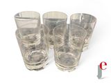 four glasses sitting next to each other on a white surface