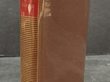 an old book sitting on top of a table next to a gray wall