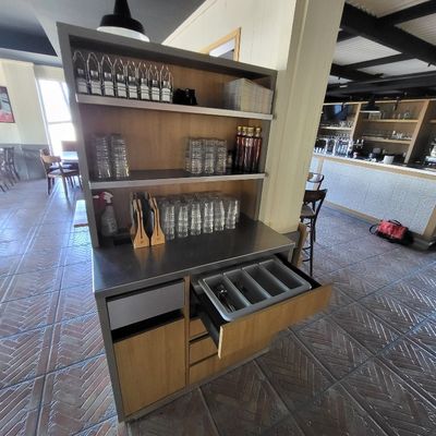 une cuisine avec un plan de travail et des étagères remplies de verres à vin