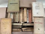 de nombreux livres anciens dans une boîte posée sur une table