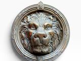 un gros plan de la tête d'un lion sur une poignée de porte
