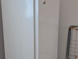 a white refrigerator next to a metal rack in a room