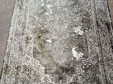 Un vieux tapis est posé par terre au milieu de la pièce.