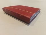 an open red book sitting on top of a white table