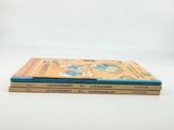 three books are stacked on top of each other on a white surface