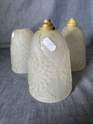 three glass vases sitting on top of a gray cloth