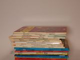 several children ' s books stacked on top of each other on a table
