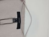 a close up of a sweater with a metal pin on it