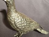 a silver bird that is sitting on a table