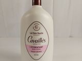 the bottle of liquid is sitting on a white surface