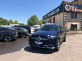 the mercedes gle parked in front of a building with cars parked in front of it