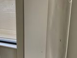 an image of a white refrigerator in a corner of a room