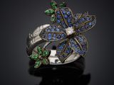 a close up of a ring with blue and green stones on it