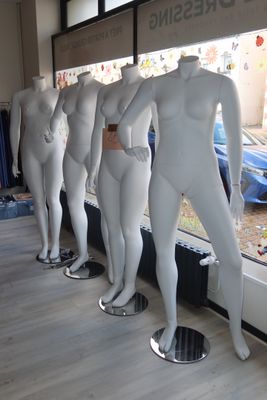 mannequins lined up in a row in front of a window