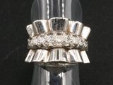 un gros plan d'une bague posée sur une surface noire, avec un fond noir