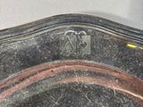 a silver plate with a bird on it sitting on a table