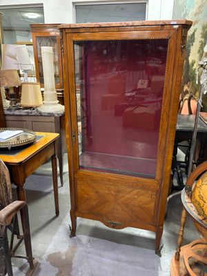 une armoire avec une porte vitrée au milieu d'une pièce