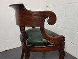 a chair with a green leather seat and a wooden frame