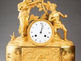 une image représentant une horloge en or surmontée de personnages
