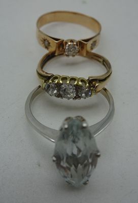 trois anneaux de couleurs différentes, sertis de diamants, sur un fond blanc
