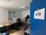 une pièce avec un bureau, une chaise et une affiche accrochée au mur