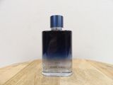 the bottle of the perfume is sitting on a wooden table
