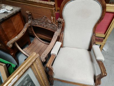 une chaise qui se trouve dans une pièce où il y a des photos par terre