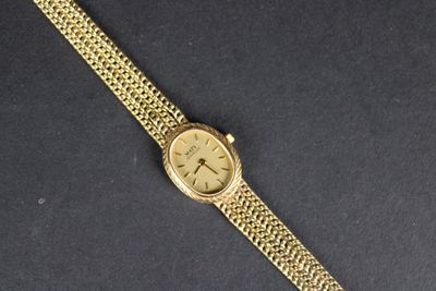 gros plan d'une montre en or sur une surface noire