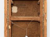 an old picture of a wooden frame with a tag attached to it