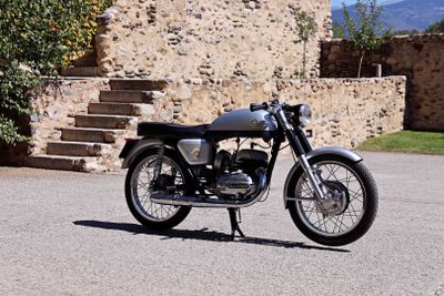a black motorcycle parked in front of a stone building