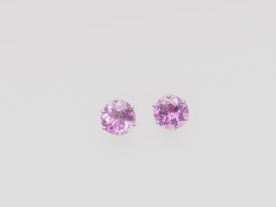 une paire de boucles d'oreilles en saphir rose sur fond blanc