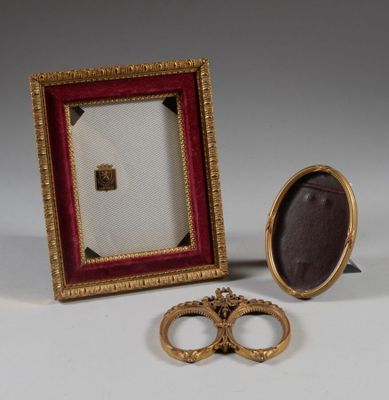 pair of gold wedding rings and a picture frame on a table