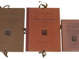trois livres sont alignés sur une surface blanche
